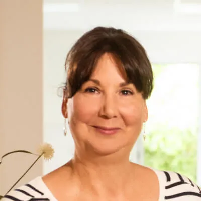 Heike Neitz freundlich steht lächelnd vor der Empfangstheke